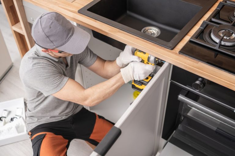 A man repairs a kitchen sink, demonstrating techniques for fixing broken corners and damaged edges on furniture.
