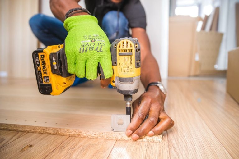 A man using a drill to install wood, demonstrating a technique for repairing stripped screw holes in furniture.